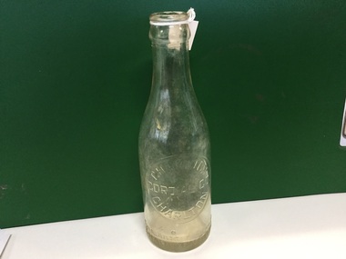 Old Charlton coridal bottle being show or a green background.