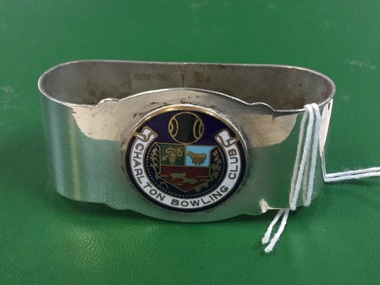Silver serviette ring containing an enameled disk, black background with enscription "Charlton Bowling Club" in a scroll and Coat of Arms for the club.