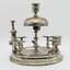 Silver stand to hold 8 pipes and pipe cleaner, A bell on top. Match striker plate and cigar cutter. Candle holder on top. Tarnished.