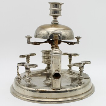 Silver stand to hold 8 pipes and pipe cleaner, A bell on top. Closer view of cigar cutter. Candle holder on top. Tarnished.