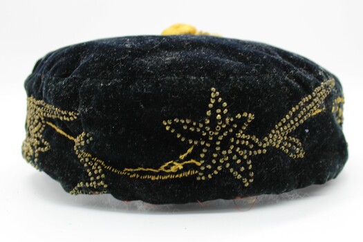 Closer view of the yellow beading on the front of the cap. Flower and leaf motif. This wraps around the brim of the cap