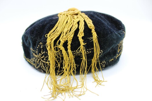 Smokers cap with the yellow tassel spread out over the cap showing the twisting of the strands.