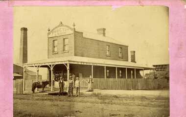 Procter and Son Butcher. Two men in butchers aprons, a woman and teenage child.  Front of shop is festooned with carcasses.