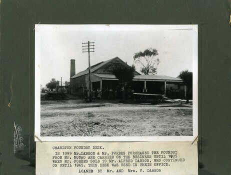 Dray parked in front of men. Large wooden building with chimney at the rear. Group of men in Learmonth St.