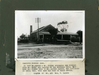 Dray parked in front of men. Large wooden building with chimney at the rear. Group of men in Learmonth St.