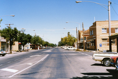 National Australia Bank on the corner of High & Armstrong Streets. Sign for Victoria Bitter and East Charlton Hotel on LH side. White car travelling toward photographer.