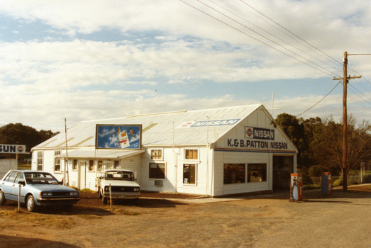 Garage is a white, weatherboard single story building with a corrugated iron roof. Small lean-to on the LH side of the building. 