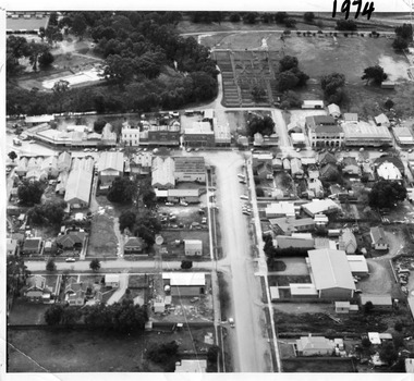 Aerial photo looking down a Armstrong street that ends in a t-intersection with High Street. In the upper right there is a two storey building with arches on its verandah.