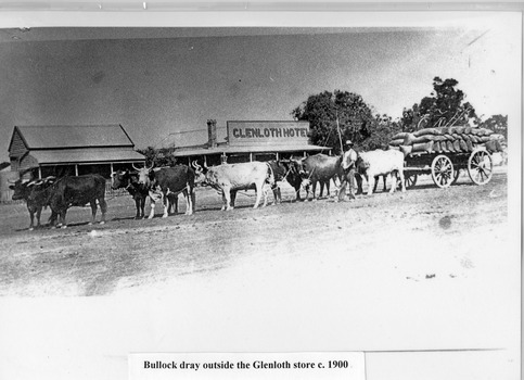 Bullock dray loaded with sacks in front of Glenloth Hotel. Team driver stand with long whip in hand.