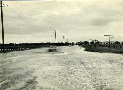 1971 Flood. Car driving through floodwater on Calder Highway.