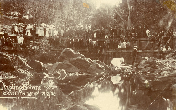 Crowd of people lined up fishing from old Charlton weir on Avoca river.