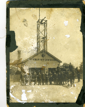 Wooden fire station c.1911. In front are the brigade members with a horse drawn fire cart.