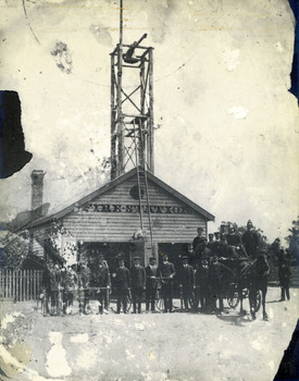 Wooden fire station c.1911. In front are the brigade members with a horse drawn fire cart.