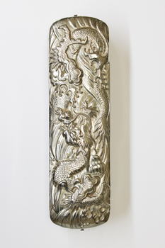 Top view of brush showing silver embossing. The embossing is of a Dragon.
