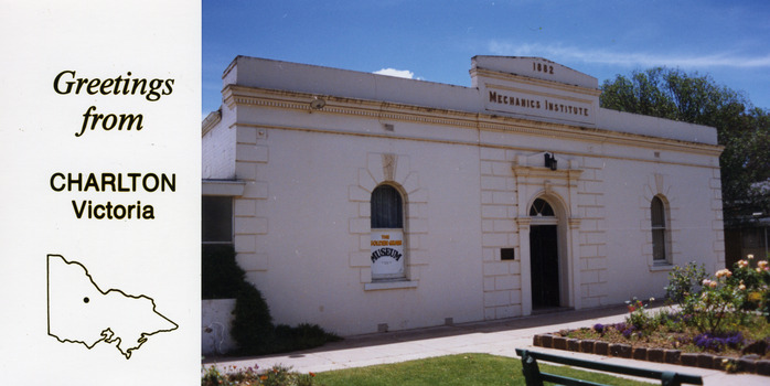 White brick building, Mechanics Institute 1882 on the building. Rose garden and lawn in front