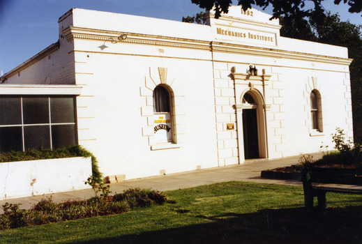 Front view of white painted, brick building. Marked as Mechanics Institute 1882 over the door.
