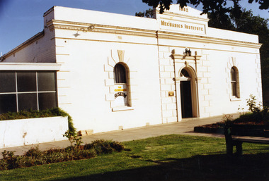 Front view of white painted, brick building. Marked as Mechanics Institute 1882 over the door.