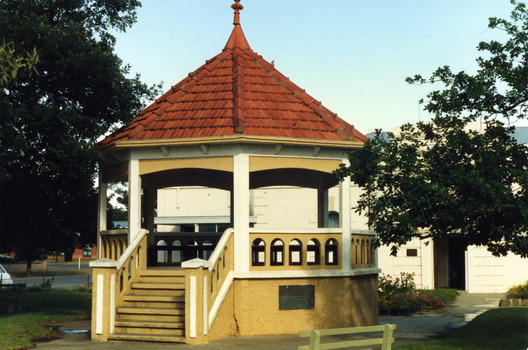 Red tiled brick rotunda in the middle of garden.