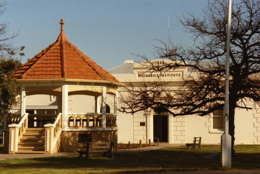 Red tiled brick rotunda in the middle of garden.