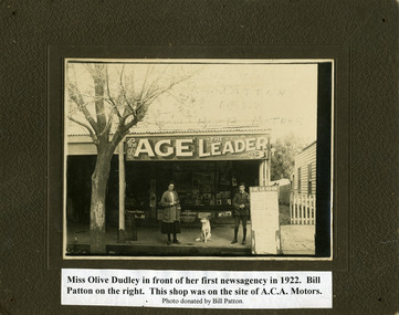 Front of a news-agency with a woman and boy standing on path.