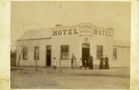 Front of Telegraph Hotel, wooden building with six people in front.