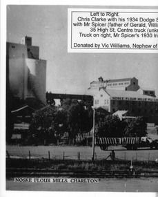 White wheat silo next to large flour mill. 