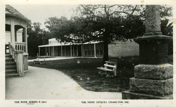 Brick shire office building with rotunda on left and war memorial on right. 