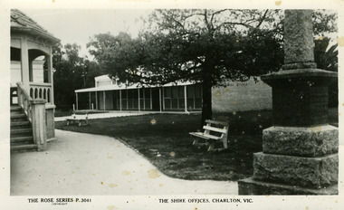 Brick shire office building with rotunda on left and war memorial on right. 