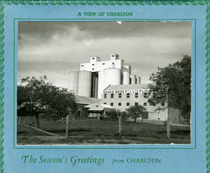 View of tall silo and a large flour mill. Painted white.
