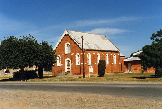 Red brick Methodist church next to church hall.
