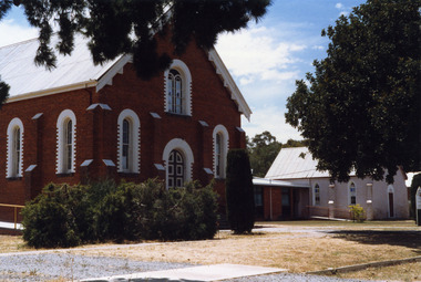 Red brick Methodist church next to church hall.