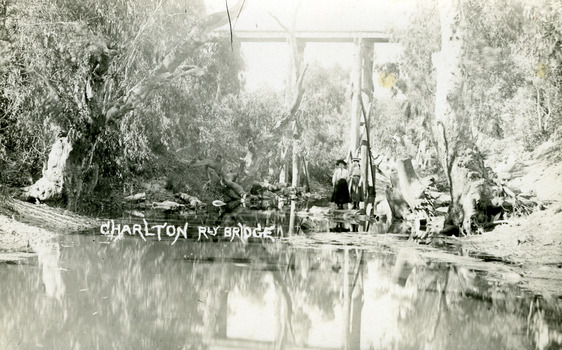 Looking along the Avoca River to the railway bridge overhead. Two girls standing on the banks of the river.