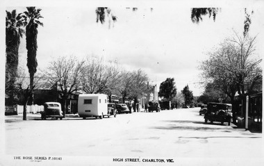 Looking along High St, Charlton. Cars and caravan along both sides of street.