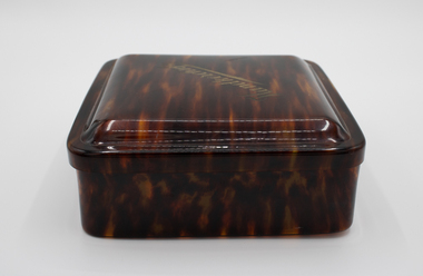 Brown and tan translucent square box with lid.