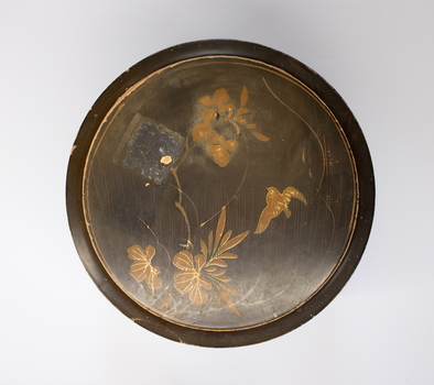 Top of a collar box. Painted with a flower and bird motif.