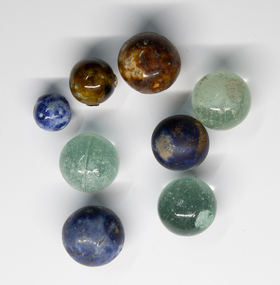 Eight marbles of various sizes and colours.