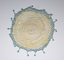 Circular lace and crochet milk jug cover with blue beads.