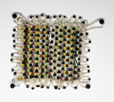 Handmade Table Mat of small glass beads  in plain weave. Colours used are black, green and yellow.