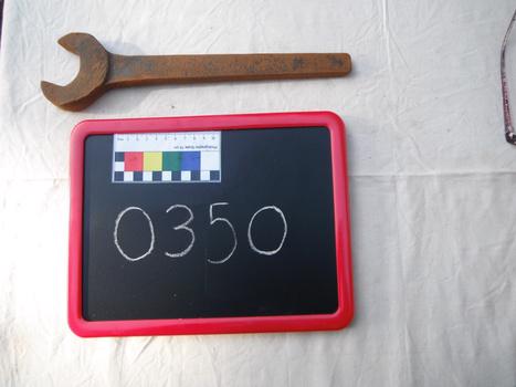 photograph of rusted spanner on white sheet