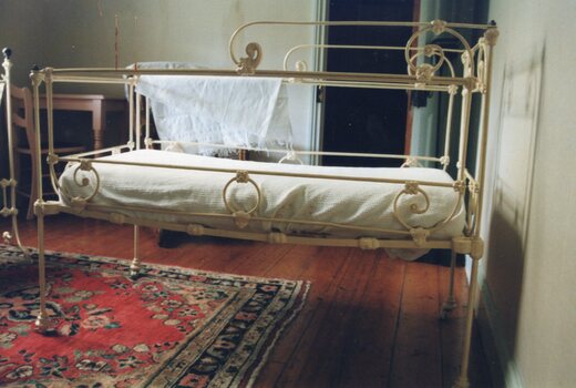 white cast iron cot with railing