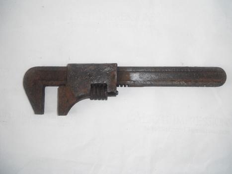 photograph of a pipe wrench on white sheet