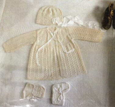 knitted layette and socks in glass box