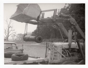 Photograph of tractor lifting cannon, <1975
