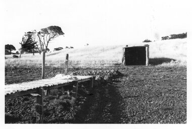 Photograph showing a jetty and a square boatshed