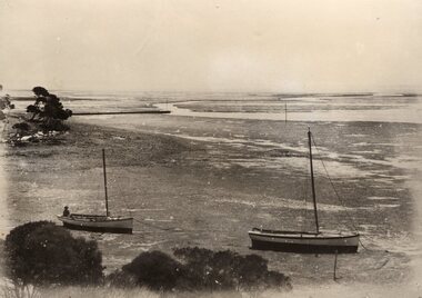 Photograph showing two boats resting on the mud, 19th century