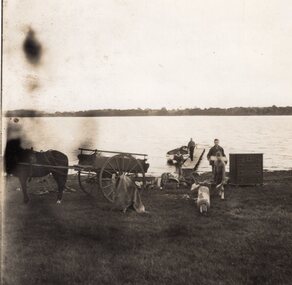 Photograph of men loading a cart from the ferry, Unknown