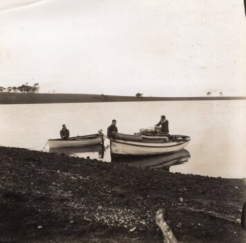Photograph of two small boats pulled up to the shoreline
