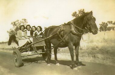 Photograph - Black and white photograph of four women in a cart