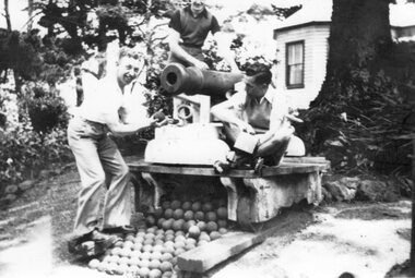 Photograph - Black and white photograph of three men on a cannon, c.1940