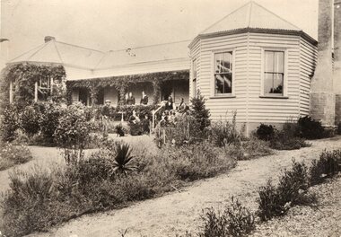 Photograph of family standing around Amess House 